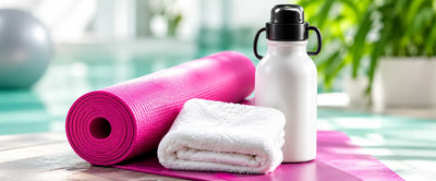 Yoga mat, towel and water bottle by a pool